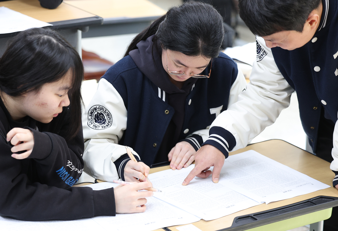 Senior students at Jeonghwa Girls’ High School in Daegu check their scores Friday,  the day after the 2026 College Scholastic Ability Test. (Yonhap)