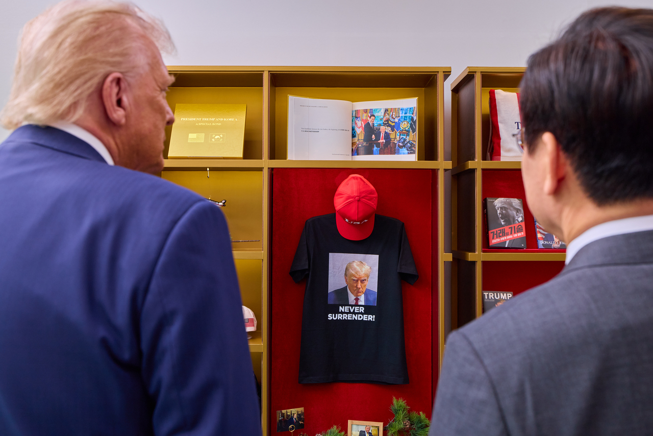 President Lee Jae Myung (right) and President Donald Trump look at Trump-related books and merchandise ahead of their summit at the Gyeongju National Museum on Oct. 29. (Presidential Office)