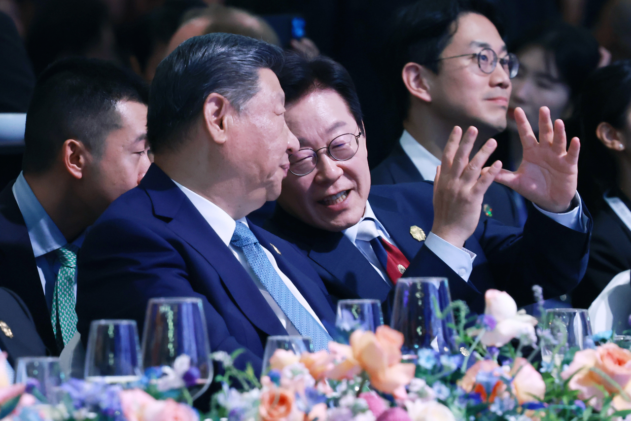 President Lee Jae Myung (right) converses with Chinese President Xi Jinping during a the APEC 2025 gala dinner in Gyeongju, North Gyeongsang Province, Friday. (Yonhap)