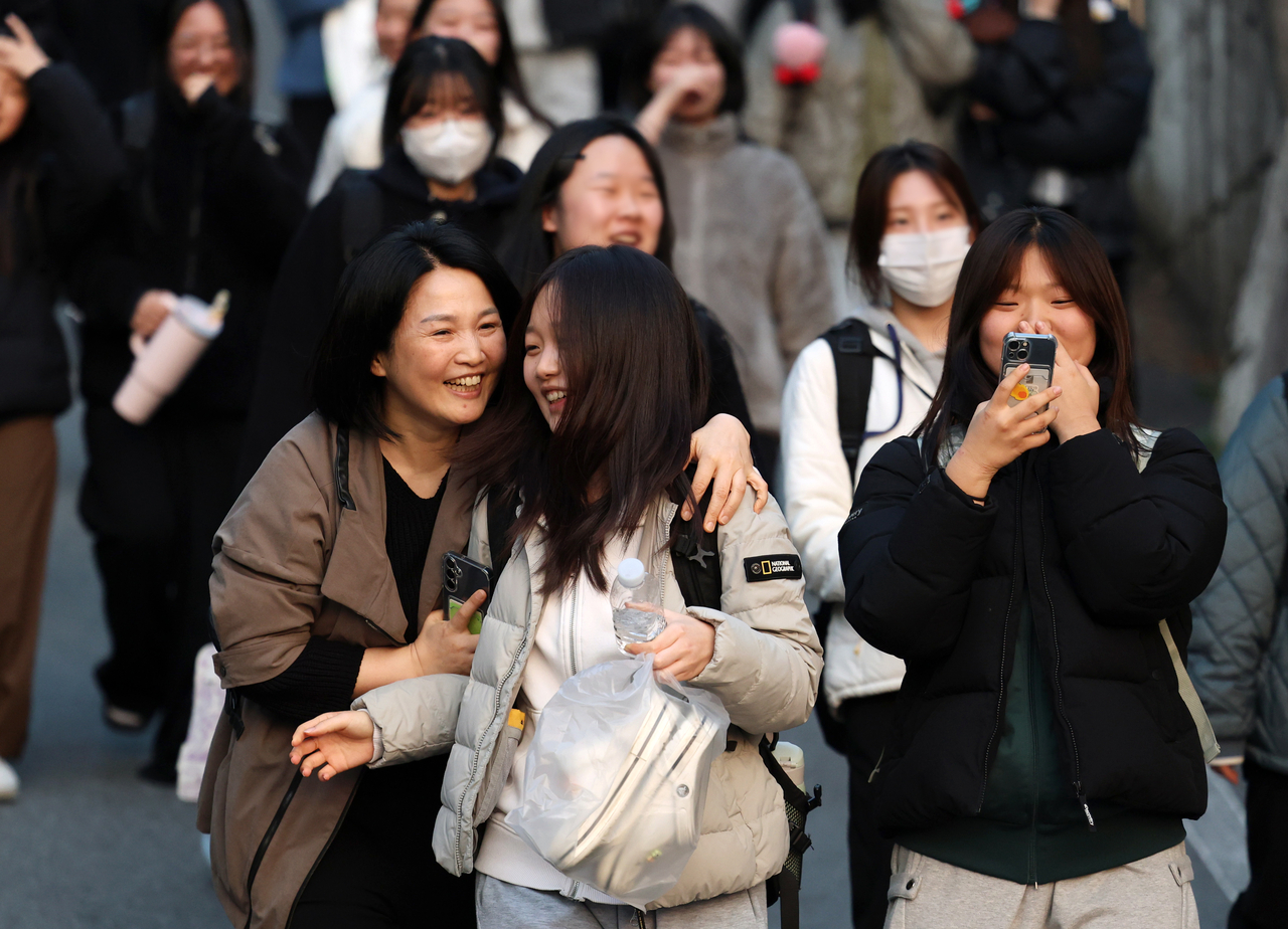 A student reunites with her family after finishing the 2026 College Scholastic Ability Test at Donga Girls’ High School in Nam-gu, Gwangju, Thursday. (Yonhap)