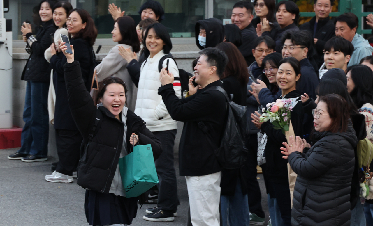 A test-taker cheers as she leaves Ewha Girls’ Foreign Language High School in Seoul after taking the Suneung on Thursday. (Yonhap)