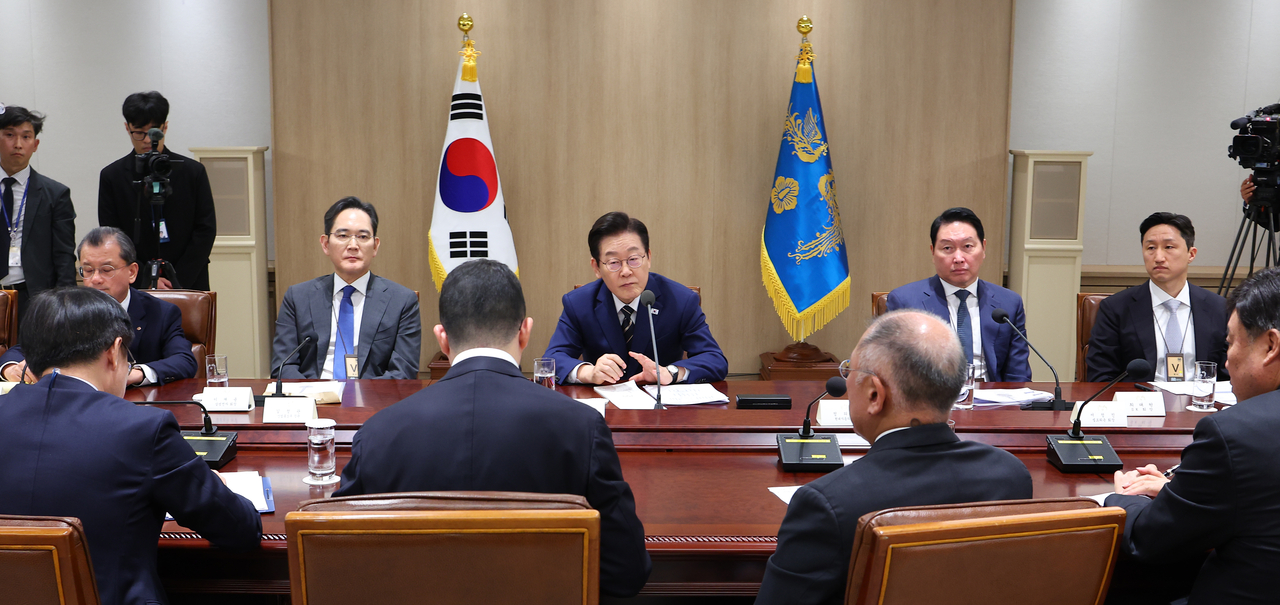 South Korean President Lee Jae Myung (center) speaks during a meeting with conglomerate chiefs at the presidential office in Seoul on Sunday. (Yonhap)