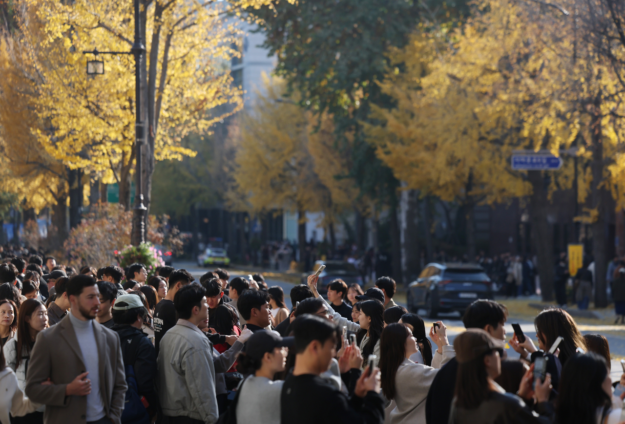Young South Koreans enjoy autumn in Jongro-gu, Seoul on Sunday. (Yonhap)