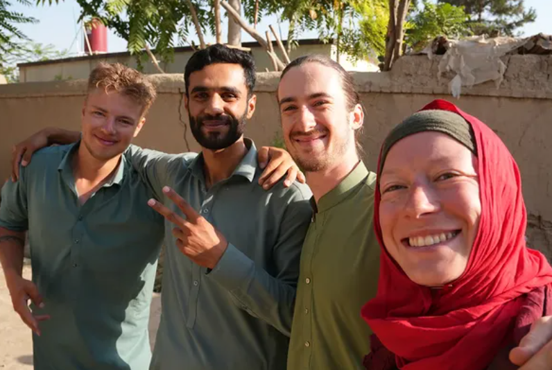 Philipp Springsguth (second from right) and Maria West (right) pose for a photo with locals in Afghanistan. (Springsguth and West)